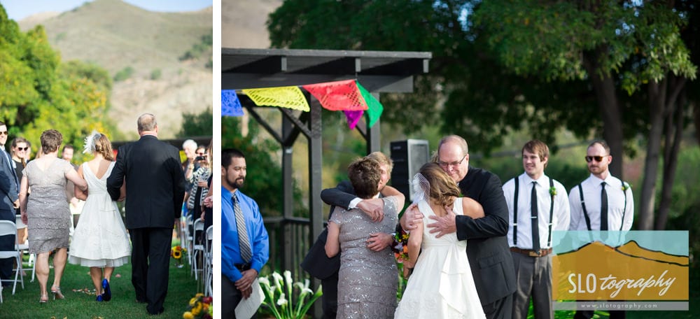 father escorts bride down aisle and hugs
