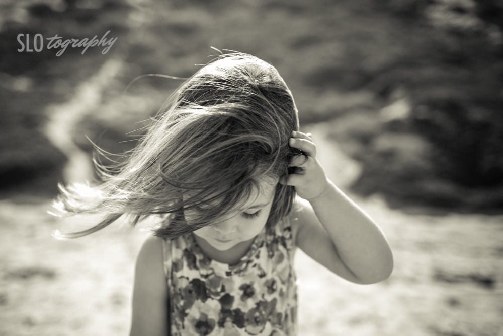 Little Girl Brushes Hair on Beach